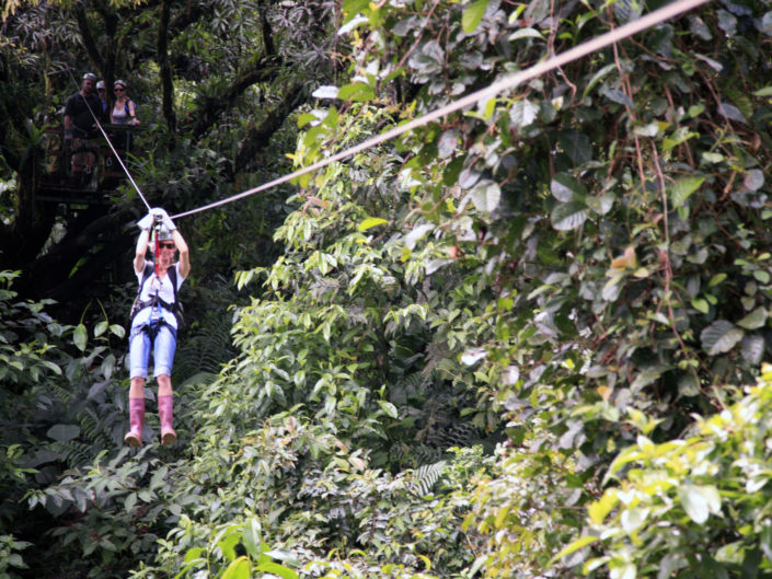 woman ziplining in the jungle
